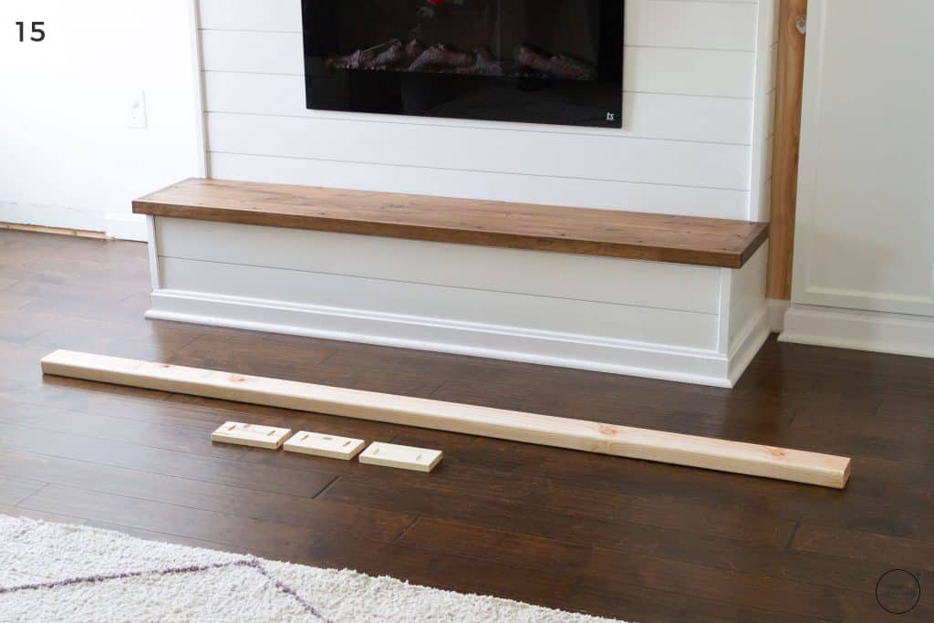 a wooden hearth below an electric fireplace with ship lap surround