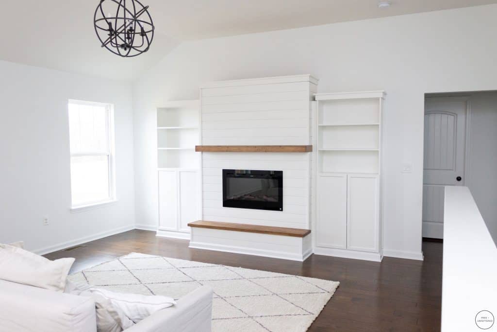 living room featuring a modern farmhouse shiplap electric fireplace and built-in Billy bookcases from IKEA