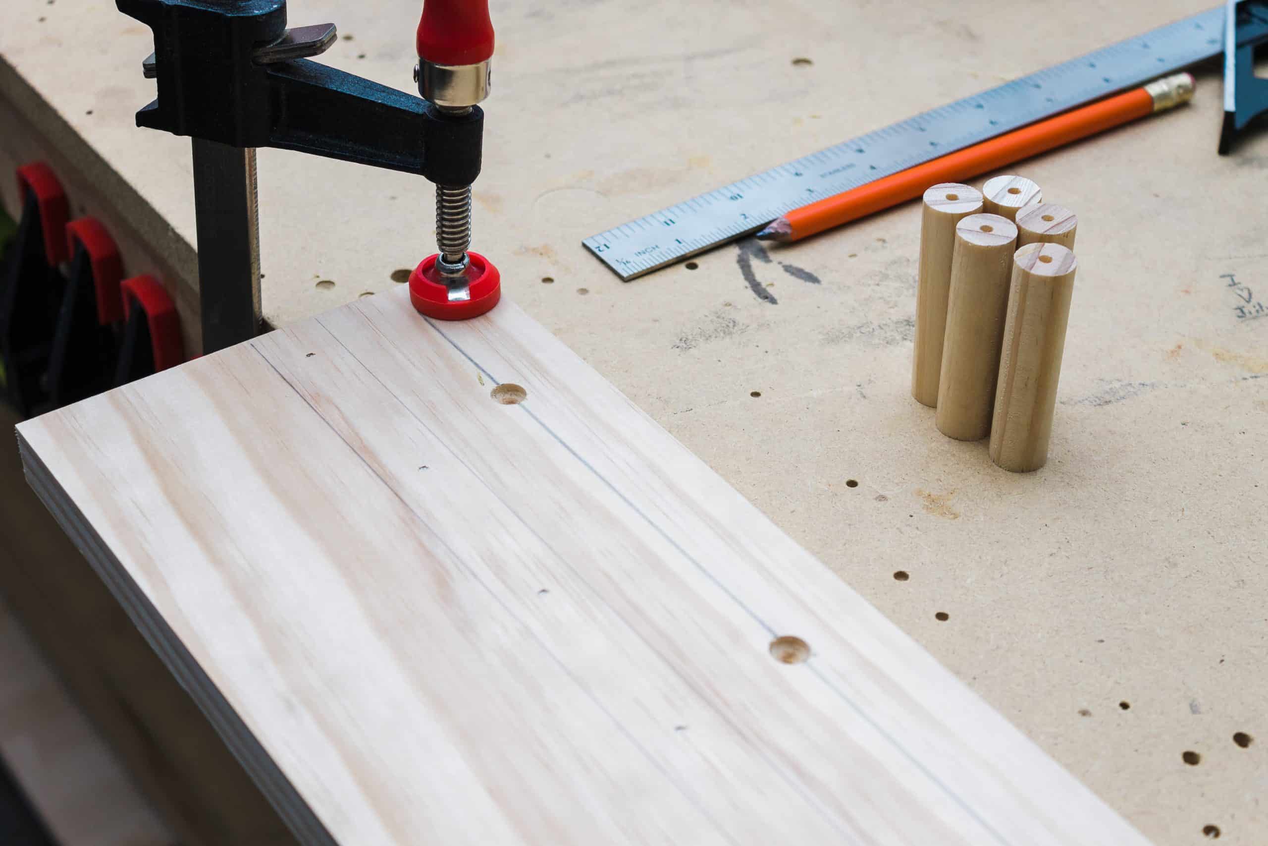 For an easier assembly, pre-drill center holes in each of the dowels for the DIY wooden peg rail shelf. 