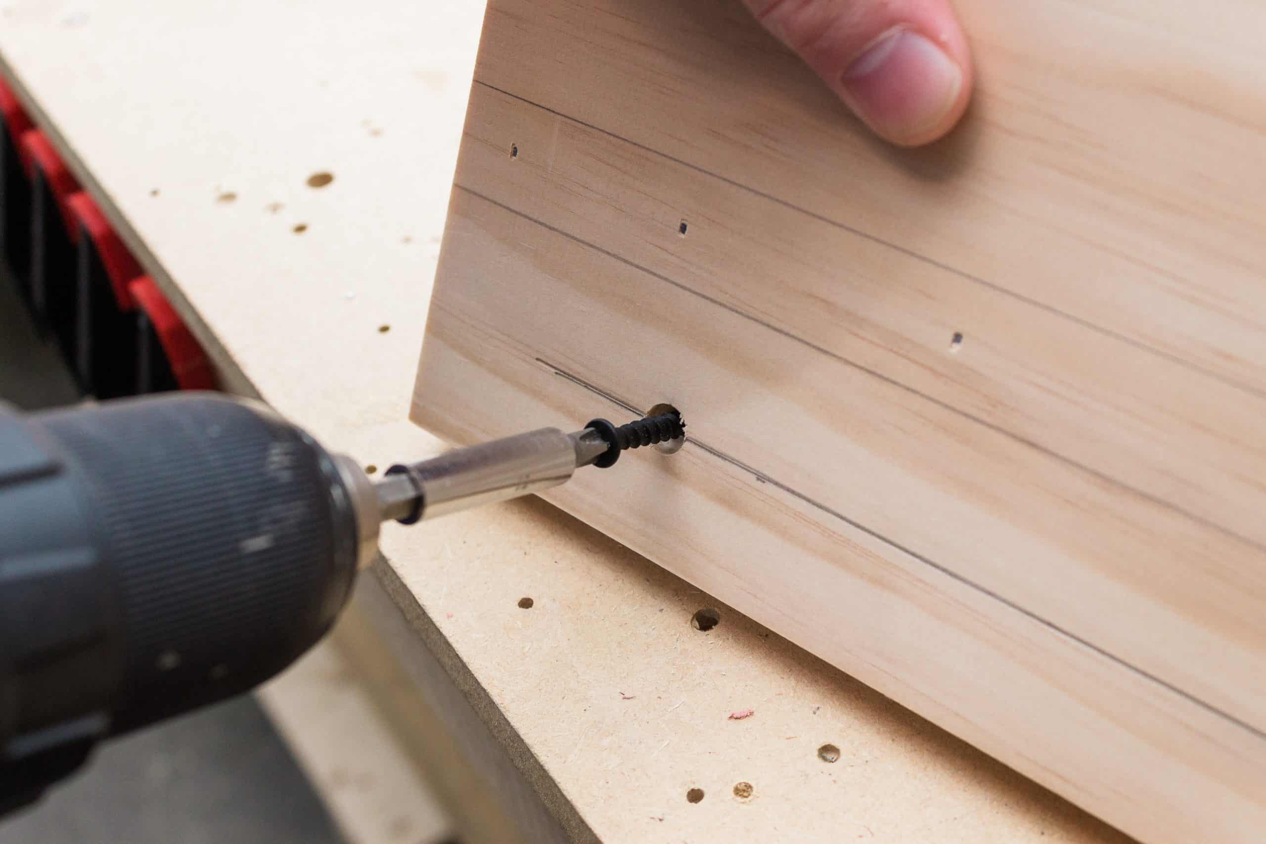 Use a countersink bit to drill the holes for the dowels when assembling the peg rail shelf. 