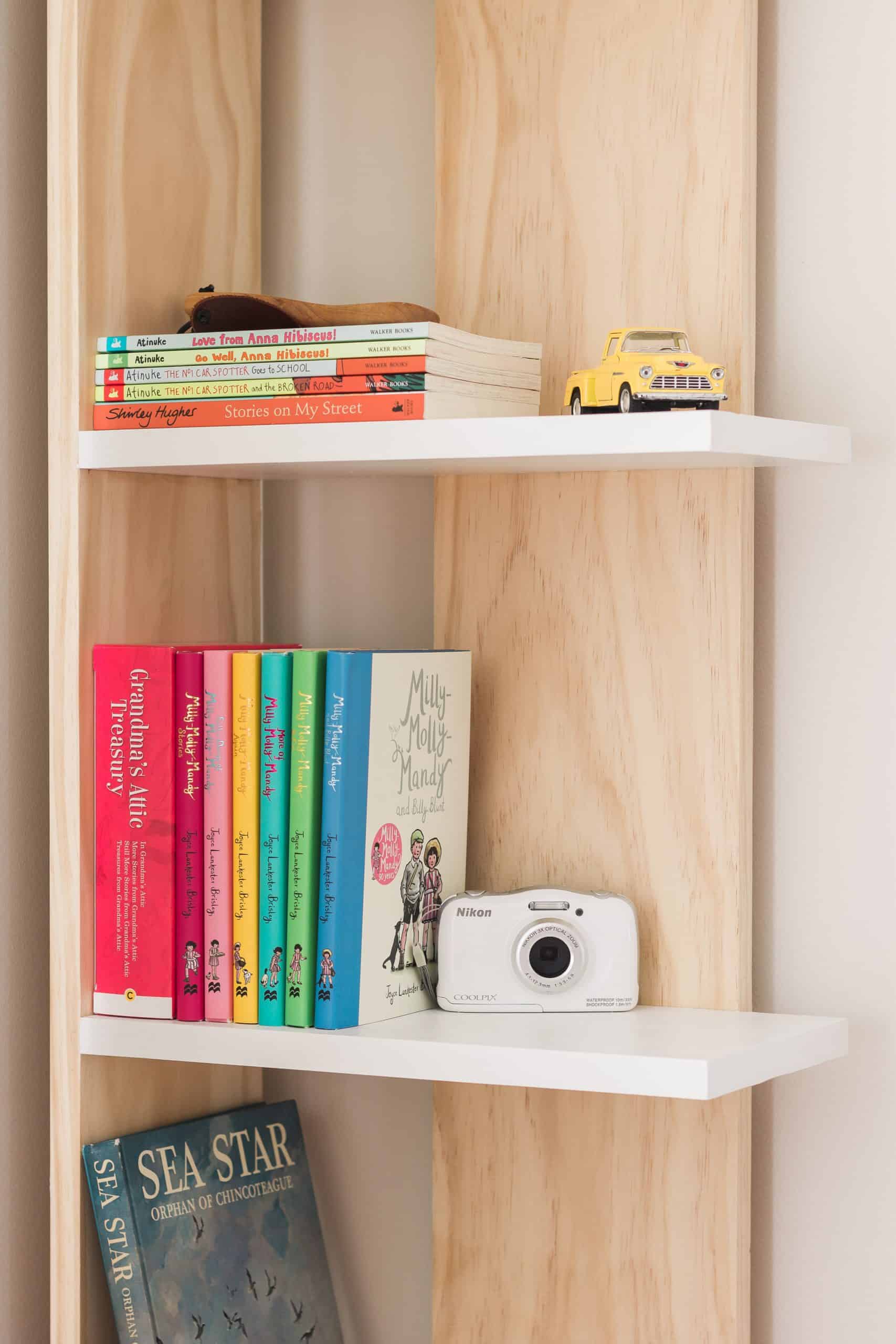 Turn into unused corner into a functional storage space with this easy-to-build and budget-friendly bookcase! You can build it in a day for just $60 dollars. See the complete tutorial at www.freeandunfettered.com. It's perfect for small space living! #diy #bookcase #bookstorage #diyfurniture #modernhome #homeorganization #storageandorganization #diyproject #budgetfriendlydecor #smallspaceliving