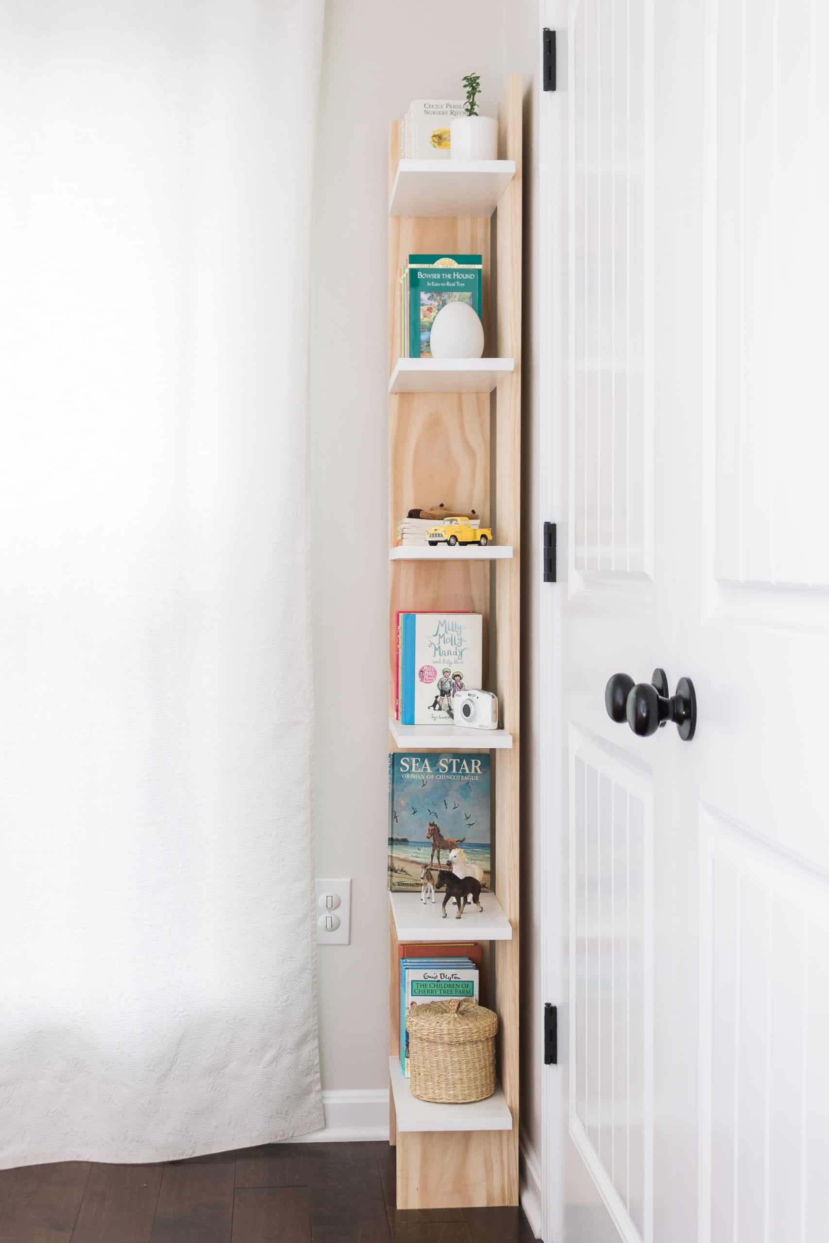 Turn into unused corner into a functional storage space with this easy-to-build and budget-friendly bookcase! You can build it in a day for just $60 dollars. See the complete tutorial at www.freeandunfettered.com. It's perfect for small space living! #diy #bookcase #bookstorage #diyfurniture #modernhome #homeorganization #storageandorganization #diyproject #budgetfriendlydecor #smallspaceliving