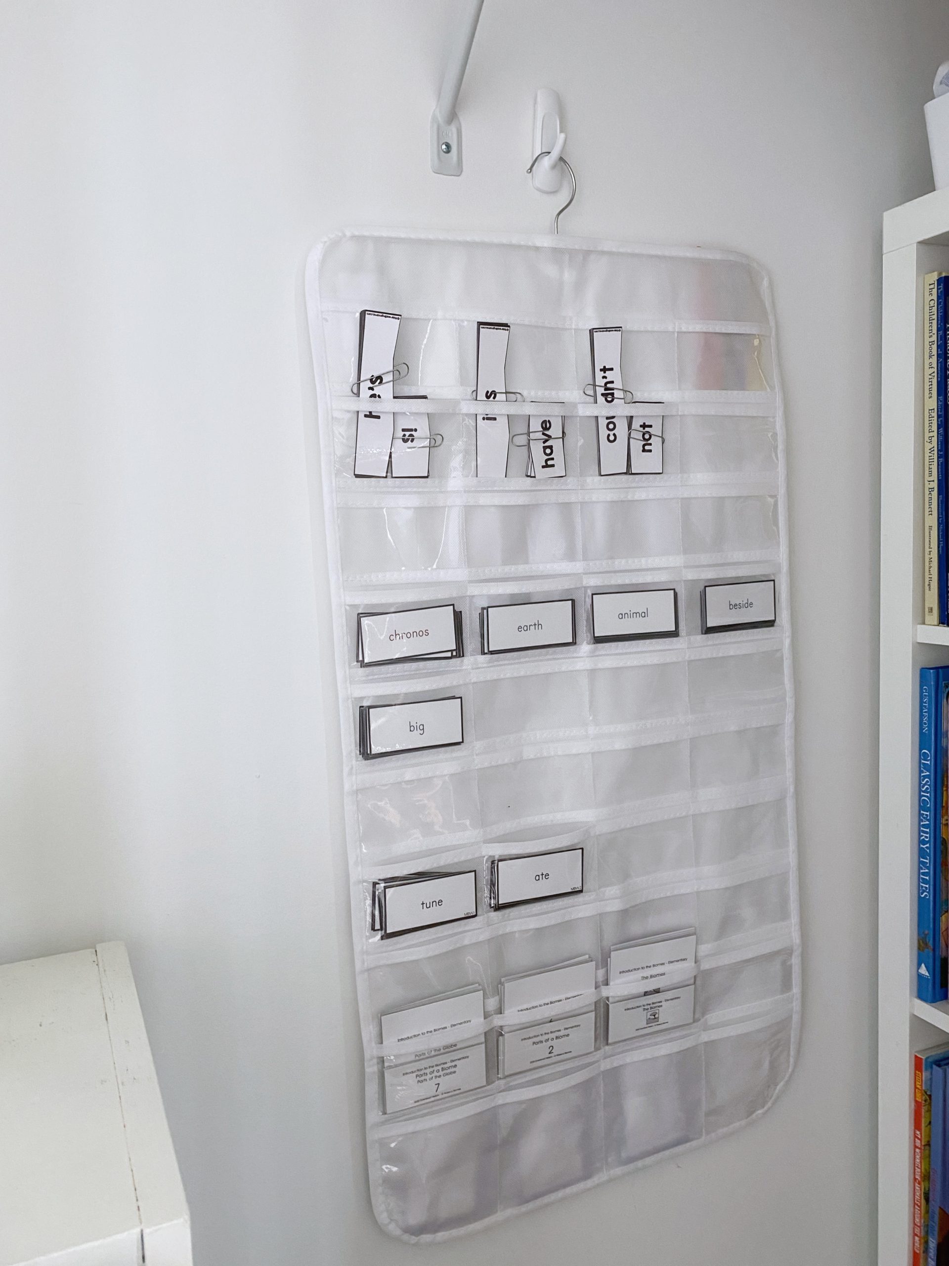 A hanging jewelry organizer stores Montessori nomenclature cards and other lower elementary task cards and activities. 