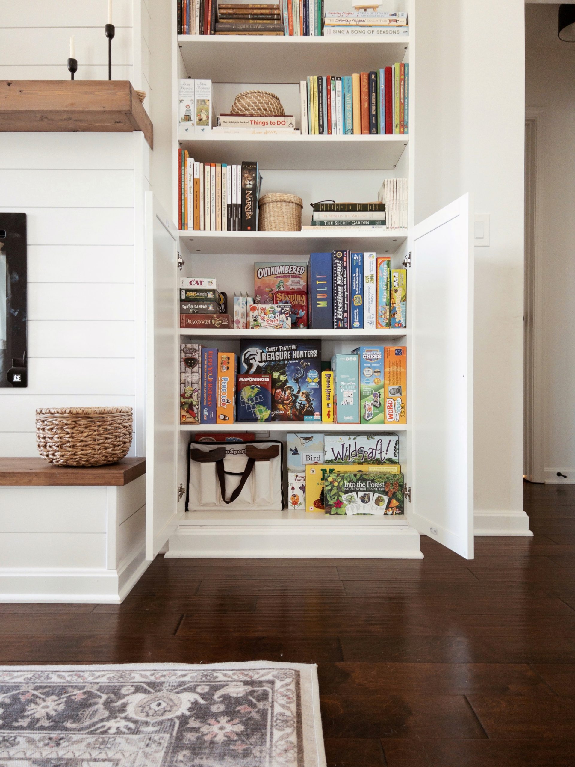 DIY Electric Fireplace with Built-In BILLY Bookcases from IKEA being used for board game storage in the living room.