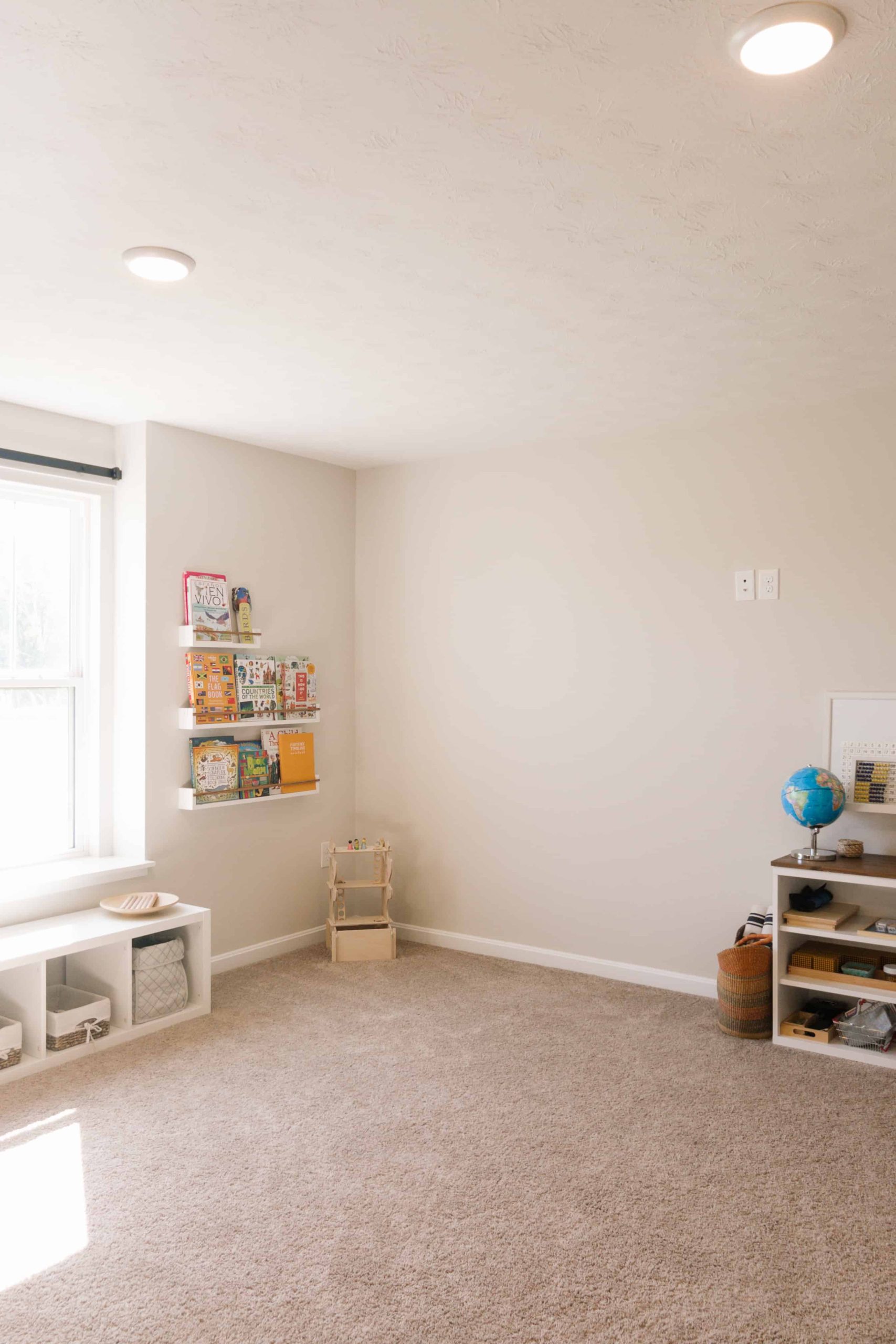 Our Montessori homeschool room includes plenty of space for open-ended toys and a book nook with custom-made floating book ledges. 